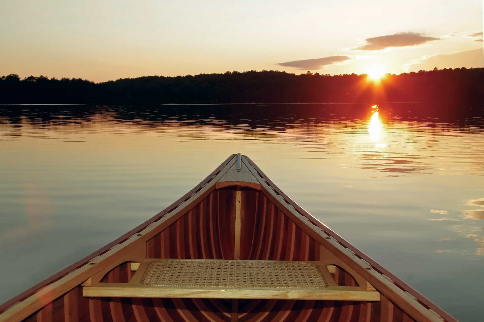 Canoe on water at sunset