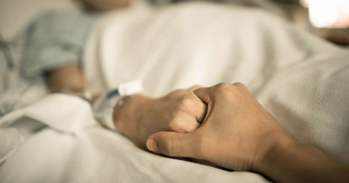 holding hands in hospital bed